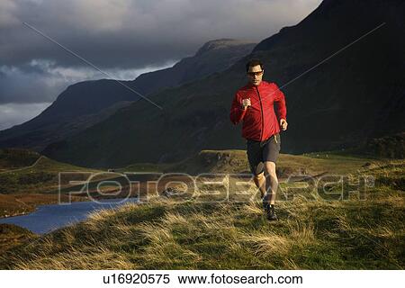 Hiker running on grassy hillside View Large Photo Image Stock Photography - Hiker running on grassy hillside. Fotosearch
