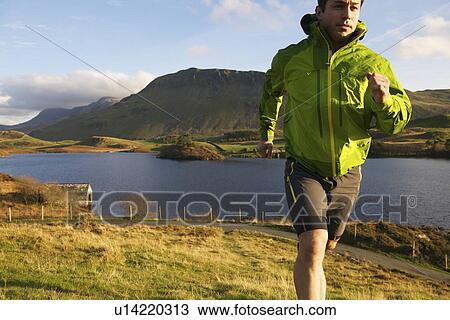 Hiker running up grassy hillside View Large Photo Image Stock Image - Hiker running up grassy hillside. Fotosearch