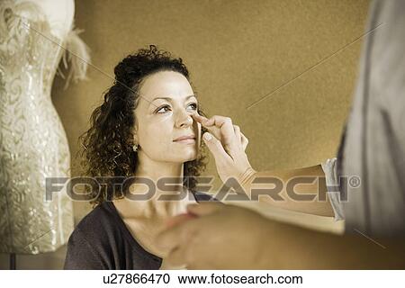 Stock Image - Make up artist working on client. Fotosearch