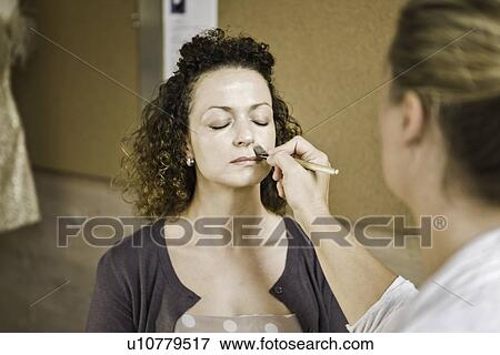 Stock Photo - Make up artist working on client. Fotosearch