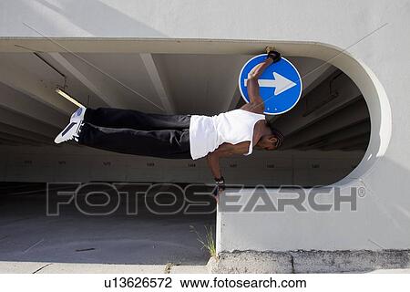 Man balancing on ledge on city street View Large Photo Image Stock Image - Man balancing on ledge on city street. Fotosearch