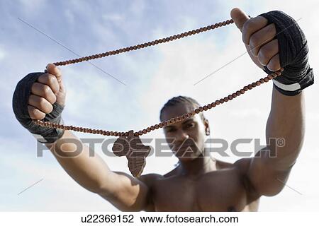 Stock Image - Man holding wooden necklace. Fotosearch