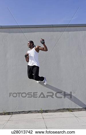Man jumping against wall outdoors View Large Photo Image Stock Image - Man jumping against wall outdoors. Fotosearch