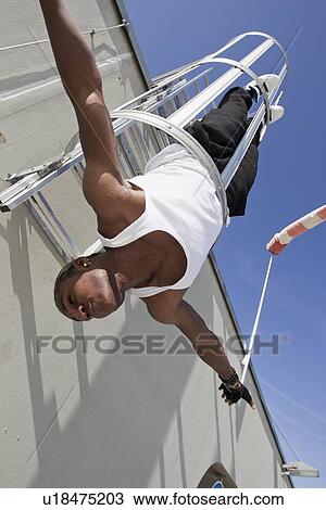 Man playing in safety escape of building View Large Photo Image Stock Image - Man playing in safety escape of building. Fotosearch