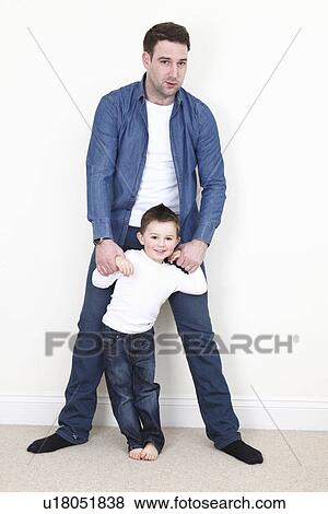 Man standing with son indoors View Large Photo Image Stock Photo - Man standing with son indoors. Fotosearch