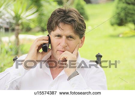 Stock Photo - Man talking on phone outdoors. Fotosearch
