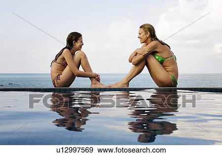 Stock Photo - Mother and daughter at edge of pool. Fotosearch