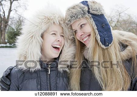 Mother and daughter laughing in snow View Large Photo Image Stock Image - Mother and daughter laughing in snow. Fotosearch