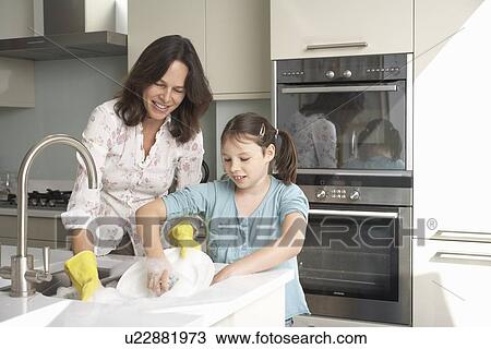 Mother and daughter washing dishes View Large Photo Image Stock Image - Mother and daughter washing dishes. Fotosearch