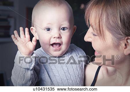 Mother holding waving baby View Large Photo Image Stock Photography - Mother holding waving baby. Fotosearch