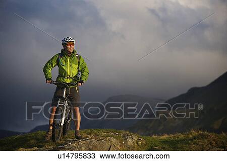 Mountain biker on grassy hillside View Large Photo Image Stock Image - Mountain biker on grassy hillside. Fotosearch