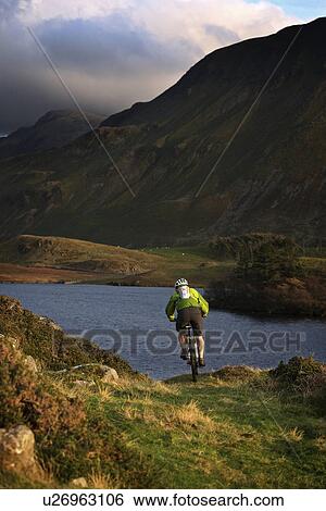 Mountain biker on grassy hillside View Large Photo Image Stock Photograph - Mountain biker on grassy hillside. Fotosearch