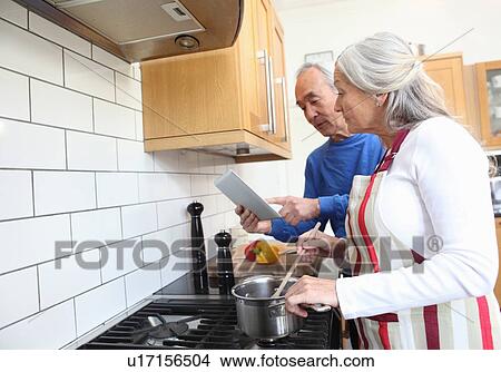 Older couple cooking together in kitchen View Large Photo Image Picture - Older couple cooking together in kitchen. Fotosearch