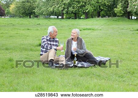 Older couple having wine at picnic View Large Photo Image Stock Image - Older couple having wine at picnic. Fotosearch