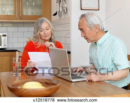 Older couple paying bills online View Large Photo Image Stock Photo - Older couple paying bills online. Fotosearch