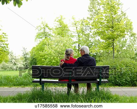 Older couple sitting on park bench View Large Photo Image Stock Photo - Older couple sitting on park bench. Fotosearch