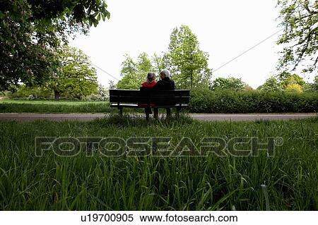 Older couple sitting on park bench View Large Photo Image Stock Photography - Older couple sitting on park bench. Fotosearch