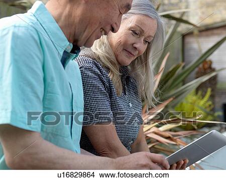 Older couple using tablet computer View Large Photo Image Picture - Older couple using tablet computer. Fotosearch