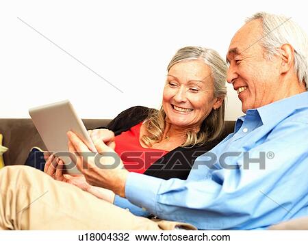 Stock Image - Older couple using tablet computer. Fotosearch