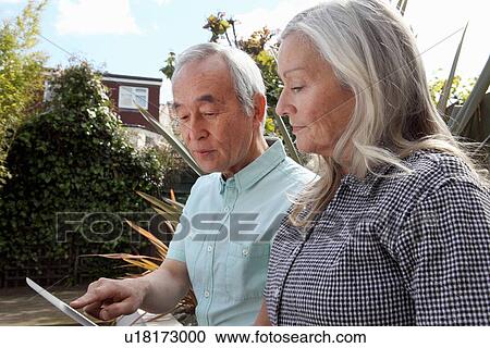 Stock Image - Older couple using tablet computer. Fotosearch