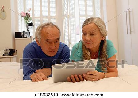 Stock Photo - Older couple using tablet computer. Fotosearch