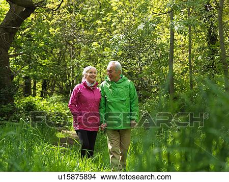 Older couple walking in forest together View Large Photo Image Picture - Older couple walking in forest together. Fotosearch