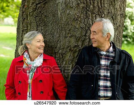 Stock Image - Older couple walking together in park. Fotosearch