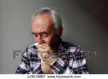 Older man coughing into napkin View Large Photo Image Stock Photo - Older man coughing into napkin. Fotosearch