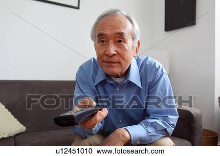 Stock Image - Older man watching television. Fotosearch