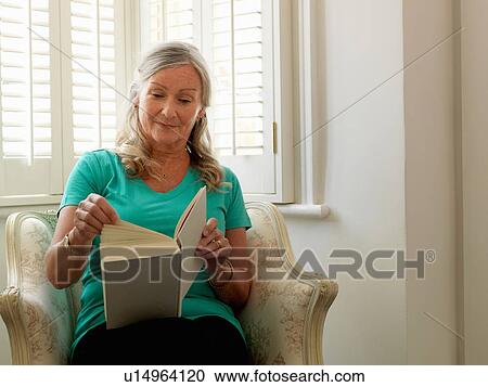 Older woman reading in armchair View Large Photo Image Stock Image - Older woman reading in armchair. Fotosearch