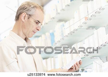Pharmacist examining box of pills View Large Photo Image Picture - Pharmacist examining box of pills. Fotosearch