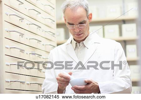 Pharmacist using pestle and mortar View Large Photo Image Stock Photography - Pharmacist using pestle and mortar. Fotosearch
