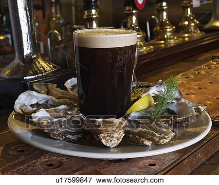 Plate of oysters and stout in bar View Large Photo Image Stock Photo - Plate of oysters and stout in bar. Fotosearch