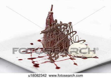 Stock Image - Poached pear with ice cream and sauce. Fotosearch