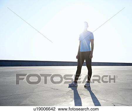 Runner standing on rooftop View Large Photo Image Stock Image - Runner standing on rooftop. Fotosearch
