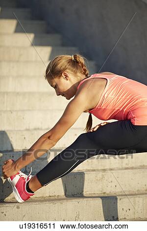 Stock Image - Runner stretching on staircase. Fotosearch