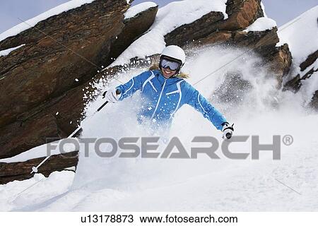 Stock Image - Skier coasting on snowy slope. Fotosearch