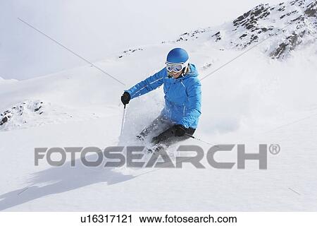 Stock Image - Skier coasting on snowy slope. Fotosearch