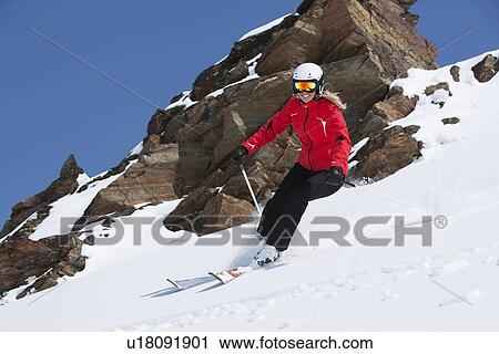 Stock Image - Skier coasting on snowy slope. Fotosearch