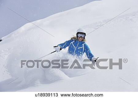 Stock Image - Skier coasting on snowy slope. Fotosearch
