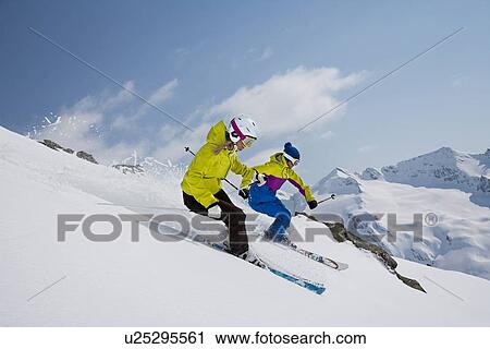 Skiers coasting on snowy slope View Large Photo Image Stock Image - Skiers coasting on snowy slope. Fotosearch