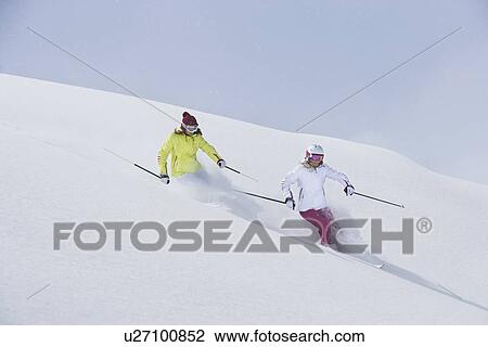Stock Image - Skiers coasting on snowy slope. Fotosearch
