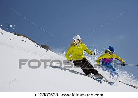 Skiers coasting on snowy slope View Large Photo Image Stock Photo - Skiers coasting on snowy slope. Fotosearch