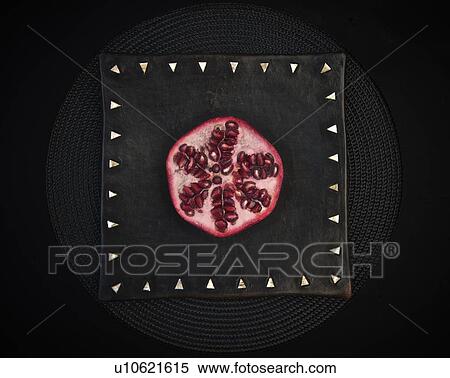 Stock Photography - Sliced pomegranate on decorative board. Fotosearch