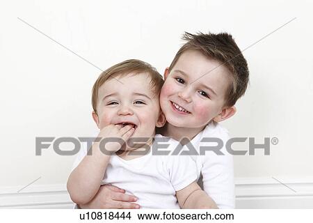 Picture - Smiling boy holding baby brother. Fotosearch