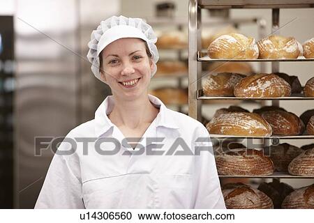 Stock Image - Smiling chef standing in kitchen. Fotosearch