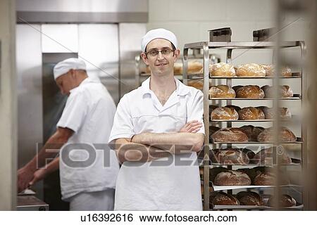 Stock Photograph - Smiling chef standing in kitchen. Fotosearch