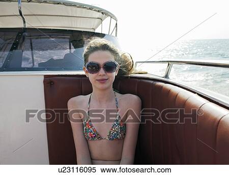Smiling girl wearing sunglasses on boat View Large Photo Image Stock Photography - Smiling girl wearing sunglasses on boat. Fotosearch