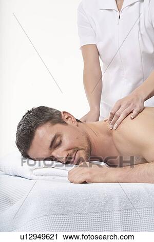 Smiling man having back massage View Large Photo Image Stock Image - Smiling man having back massage. Fotosearch