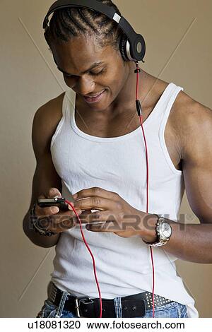 Smiling man listening to headphones View Large Photo Image Stock Image - Smiling man listening to headphones. Fotosearch